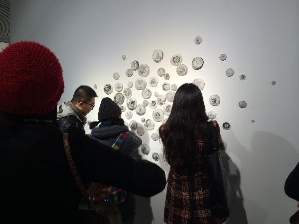 图为:观展人员驻足观看我校学子作品 图为:观展人员驻足观看我校学子作品
